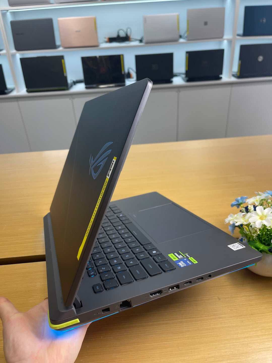 ASUS ROG Strix G16 open at an angle, showing the RGB light bar and right-side ports including HDMI, USB-A and USB-C