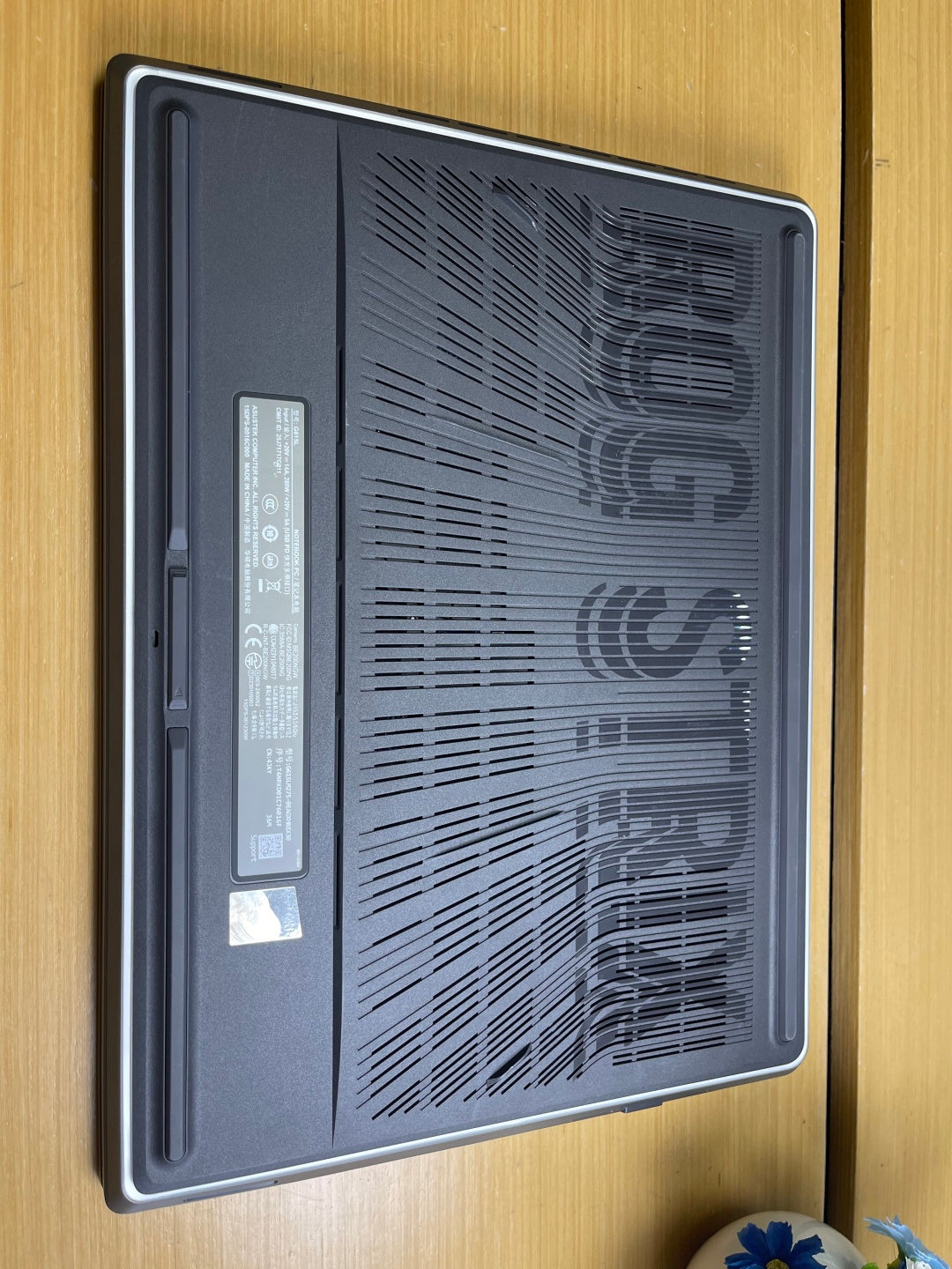 Underside of the ASUS ROG Strix G16 showing the ventilation grille and regulatory label