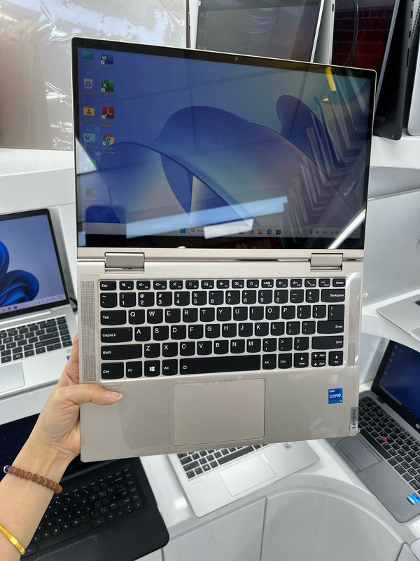 Lenovo Yoga C740 in champagne gold held open, showing keyboard and touchscreen